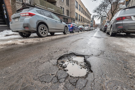 Montreal, CA - 13 March 2019: Large pothole in Montreal street, in Winterのeditorial素材