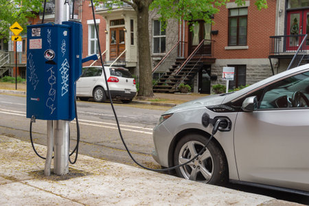 Montreal, CA - 25 May 2019: Chevrolet Volt electric car plugged into an EV charging station.