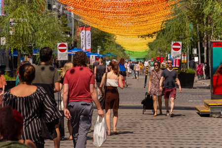 Montreal, CA - 27 July 2019: People walking below the Rainbow balls art installation "18 shades of gay" on Saint-Catherine Street in the Gay Villageのeditorial素材
