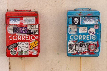 Lisbon, Portugal - 8 March 2020: Two red and blue mailboxes covered with stickers