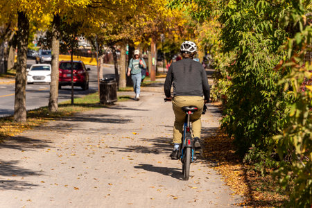 Montreal, CA - 10 October 2019: Cyclist riding a bike on Des Carrieres cycle path in Autumn.のeditorial素材