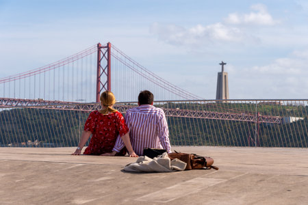 Lisbon, Portugal - 2 March 2020: Couple looking at 25 de Abril Bridge &  Sanctuary of Christ the Kingのeditorial素材