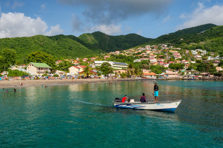Petit Anse, Martinique, 18 August 2019: Fishermen in a boat and general view over cove and hills.のeditorial素材