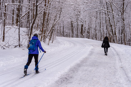 Montreal, CA - 01 January 2020: People walking or skiing on a snowy trail in Montreal's Mount Royal Park (Parc Du Mont-Royal) after snow storm.のeditorial素材