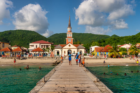 Martinique, France - 19 August 2019: Petite Anse d'Arlet village, with Saint Henri Church and pontoon.のeditorial素材
