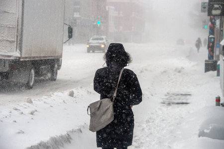 Montreal, CA - 7 February 2020: Woman walking on Pine Avenue during snow storm.