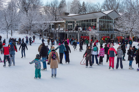 Montreal, CA - 01 January 2020: Many people ice skating at the refrigerated ice rink at the top of...