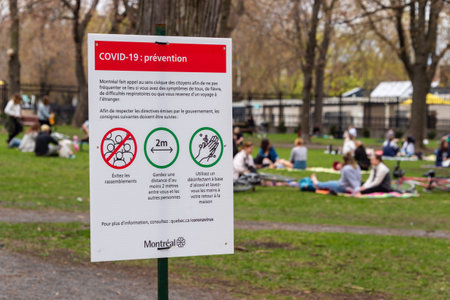 Montreal, CA - 16 May 2020 : Sign showing Covid-19 safety guidelines as many people gather in Laurier Parkのeditorial素材