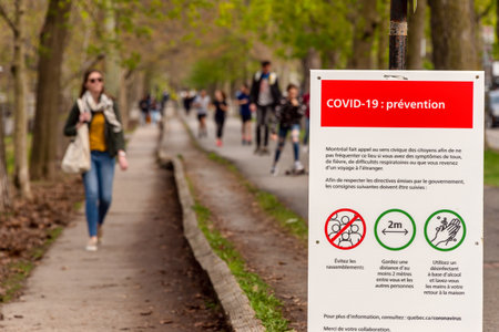 Montreal, CA - 16 May 2020 : Sign showing Covid-19 safety guidelines as many people gather in Laurier Parkのeditorial素材