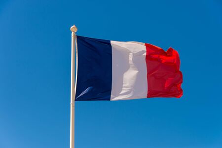 French flag waving against blue sky in Wimereux, France.の写真素材
