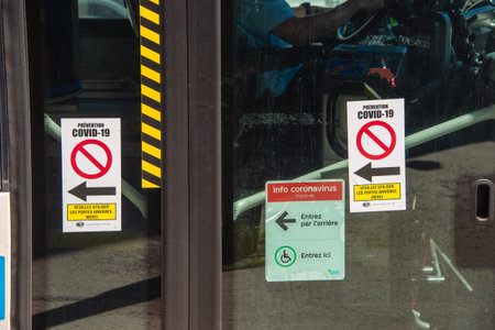 Montreal, CA - 20 May 2020: Sign on city bus asking passengers to board by the back doors only due to Covid-19 pandemic.のeditorial素材