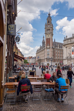 Lille, France - 15 June 2018: People walking On Pierre Mauroy street. Belfry of the Chambre de Commerce in the background.のeditorial素材