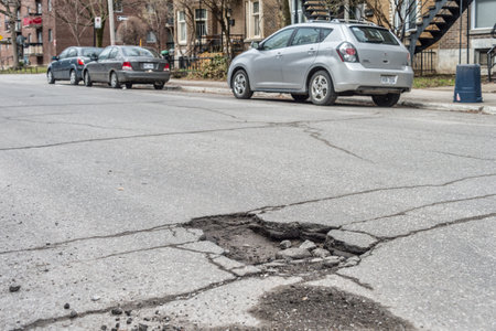 Montreal, CA - 27 April 2018: Large pothole on Gilford streetのeditorial素材