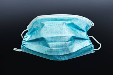 covid-19 surgical mask over dark background