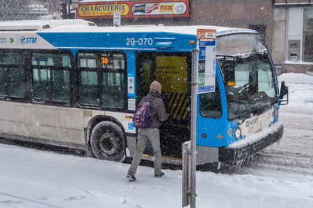 Montreal, CA - 2 February 2021: Man boarding a STM bus during snowstormのeditorial素材