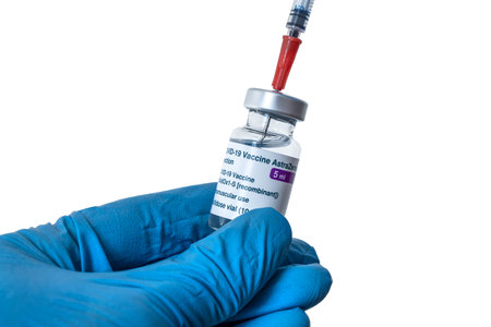 Montreal, CA - 4 March 2021: Hand in blue glove holding vial of Astrazeneca Covid-19 vaccineのeditorial素材