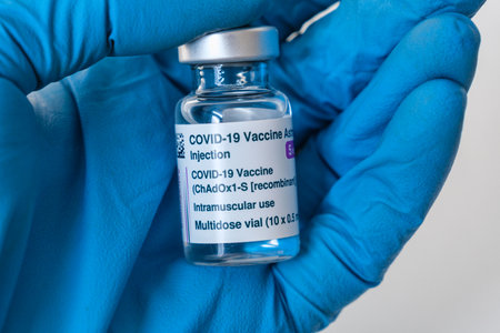 Montreal, CA - 4 March 2021: Hand in blue glove holding vial of Astrazeneca Covid-19 vaccineのeditorial素材