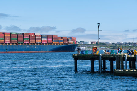 Halifax, Nova Scotia, Canada - 11 August 2021: Cargo ship sailing with hundreds of colored...