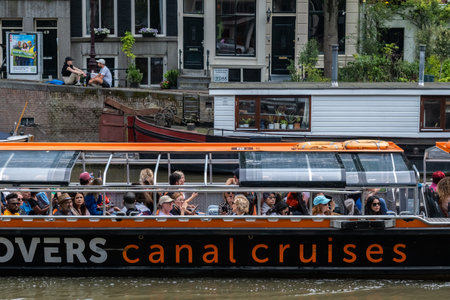 Amsterdam, The Netherlands - 21 June 2022: Cruise tourist boat in a canal