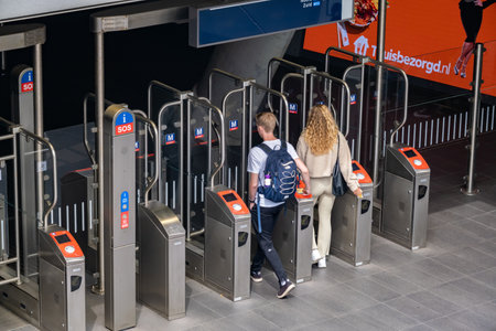 Amsterdam, The Netherlands - 21 June 2022: Two youing people entering subway station and scanning faresのeditorial素材