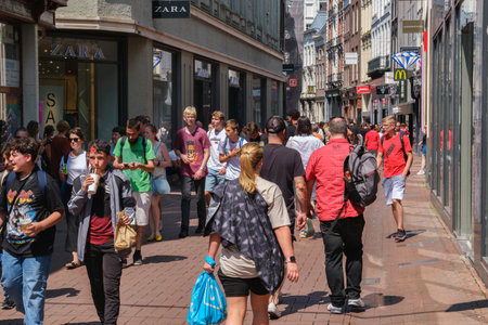 Amsterdam, The Netherlands - 23 June 2022: People walking on narrow street with many storesのeditorial素材