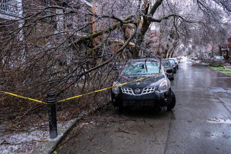 Montreal, CANADA - 5 April 2023: car under broken icy tree after freezing rainのeditorial素材