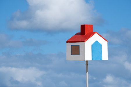 A little house standing on top of a post against the skyの写真素材