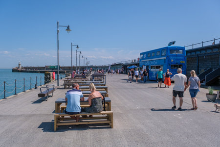 Folkestone, UK - 9 July 2023: Outdoor dining terrace, Folkestone Harbour Arm, Kent