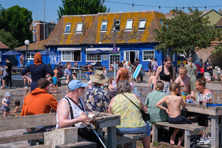 Folkestone, UK - 9 July 2023: On a hot day, children run and have fun at the city fountainsのeditorial素材