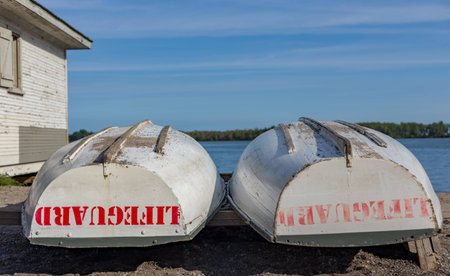 lifeguard rescue boats stored upside down on shore near shack by the lakeの写真素材