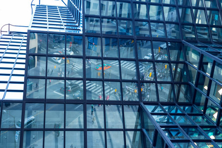 reflection of busy city traffic at intersection in divided glass exterior of corporate building