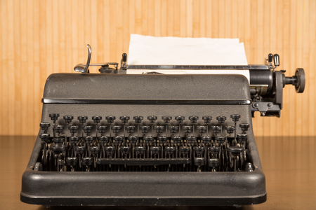 Old vintage black grey typewriter on dark wooden tableの写真素材