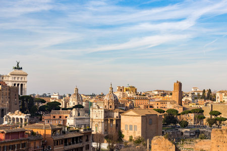 cityscape of rome italy with domes basilica monuments ruins and modern buildings on sunny day with blue sky and cloudsの写真素材