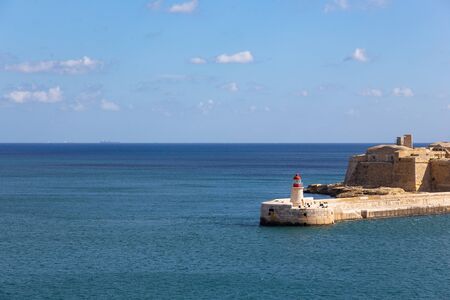 red lighthouse in Valette Malta in the mediterranean sea on a sunny dayの写真素材