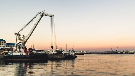 Tug boats in the harbour at sunsetの写真素材
