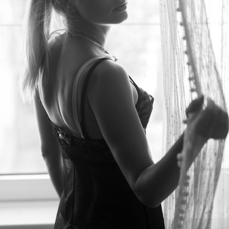 Beautiful young woman in underwear lingerie, naturally lit by the windowの写真素材