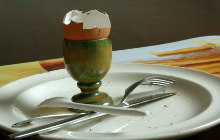 picture of a finished breakfast, the crumbs and eggshell are still on the table.の写真素材