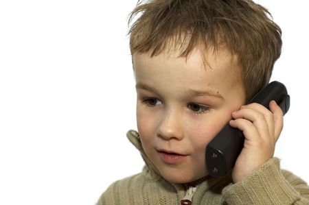 a 5-year old calling his grandma. he is listening very careful. on white background.の写真素材