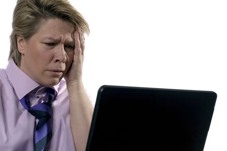 A businesswoman is having a hard day behind her laptop.の写真素材