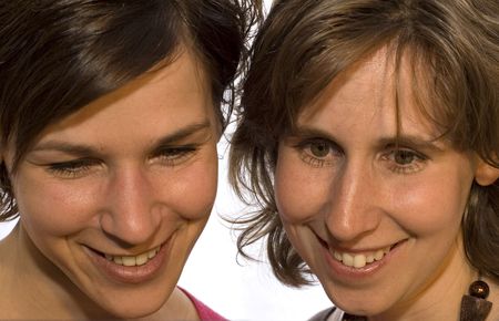 Two sisters looking down surprised and happyの写真素材