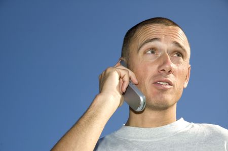 Boy on the phone looking surprisedの写真素材