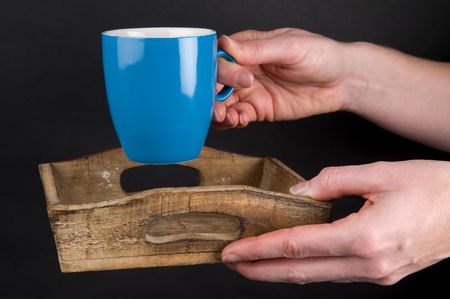Woman's hands holding a plate with a cup of coffee.の写真素材