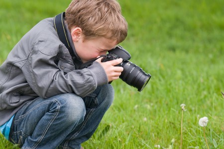 Young boy, nine years old, already practicing with an SLR shooting pictures of nature.の写真素材