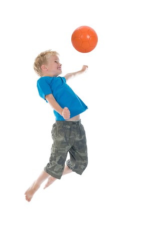 Young boy going to make a header. Will he score? Isolated on a white background. Little movement in arms and legs.の写真素材