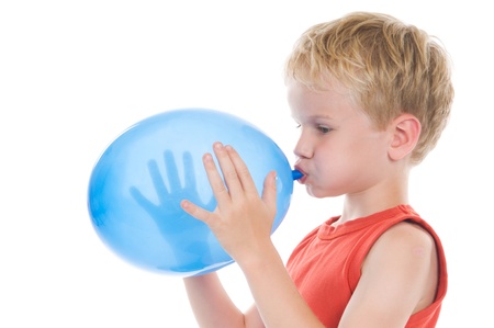 Little boy is blowing up a balloon, against a white background.の写真素材