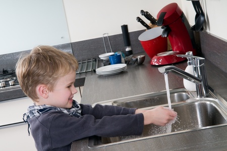 Child washing his hands before he is going cooking.の写真素材