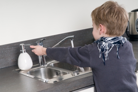 Child washing his hands before he is going cooking.の写真素材