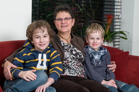 Family with two brothers and grandma in a livingroomの写真素材