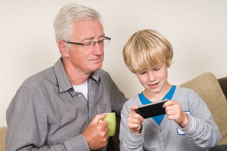 This kid learns his grandpa to use a smartphoneの写真素材