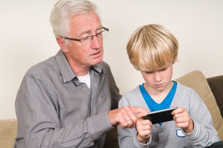 This kid learns his grandpa to use a smartphoneの写真素材